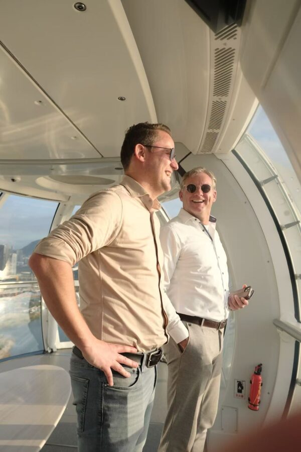 Happy Wouter and Jos on the Ferris wheel. Wouter looks out laughing, and Jos looks at Wouter, also laughing.