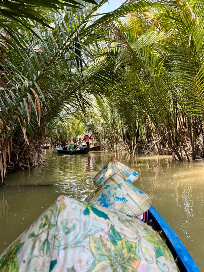 You can see the back of the heads of the people in the boat, all wearing traditional Vietnamese hats.