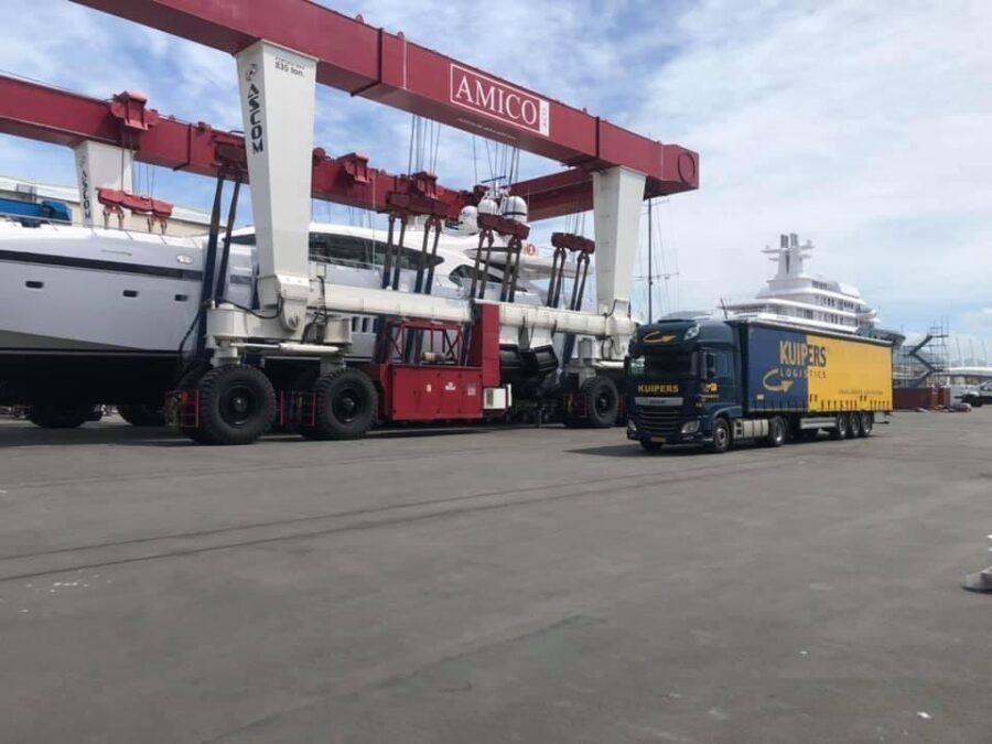 A Kuipers Logistics truck parked in front of a cruise ship at the port of Genoa