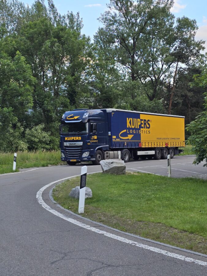 A Kuipers Logistics truck with trailer is parked at the edge of a lot.