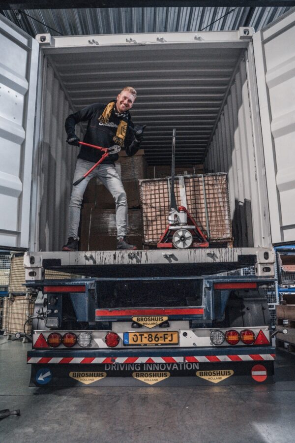 Martijn Kuipers staat in een container met een betonschaar. De container staat op de containerchassis van Kuipers Logistics