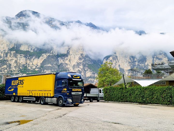Een vrachtwagen van Kuipers Logistics staat op de parkeerplaats in de bergen. Net boven de vrachtwagen hangen al wolken. De oplegger is een tautliner die onder anderen erg geschikt is voor FTL transport.