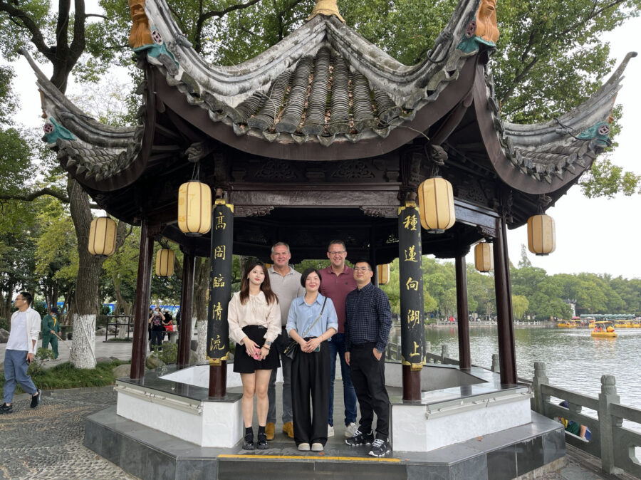 De mederwerkers van Kuipers Logistics staan met hun partners in het park onder een Chinees paviljoen