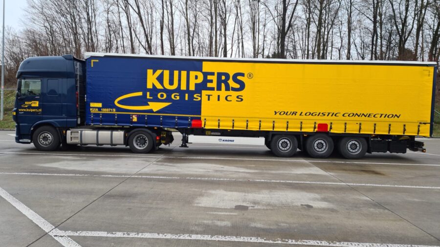 nieuwe Krone Profi liner HP 400 trailer van Kuipers logistics. De trailer is Geel met Blauw en heeft rood gekleurde vlakken aan de onderkant. Daar waar de trailer opgetild kan worden om op de trein te zetten.