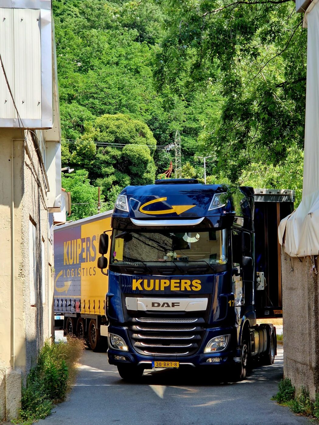 Een vrachtwagen van Kuipers Logistics rijdt een smal straatje in in Genua