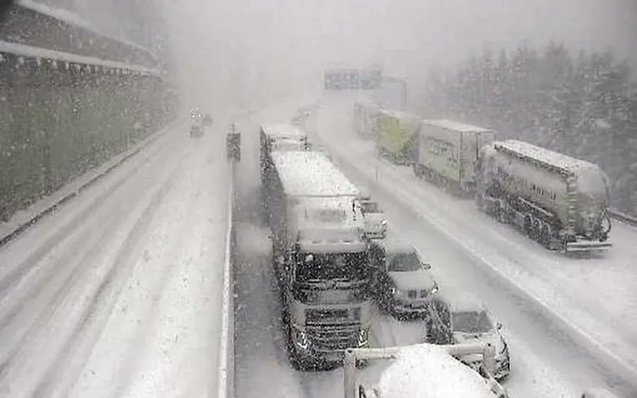 Vrachtwagens en auto's staan stil op een met 40 centimeter besneeuwde Brenner Autobahn