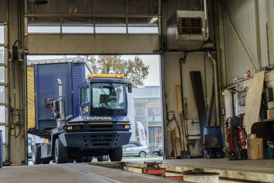 Een jonge Wouter rijdt met de terminaltrekker van Kuipers Logistics een trailer de werkplaats in.