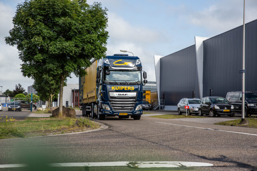 Kuipers Logistics vrachtwagen, een DAF XF rijd langs een boom op het industrieterrein.